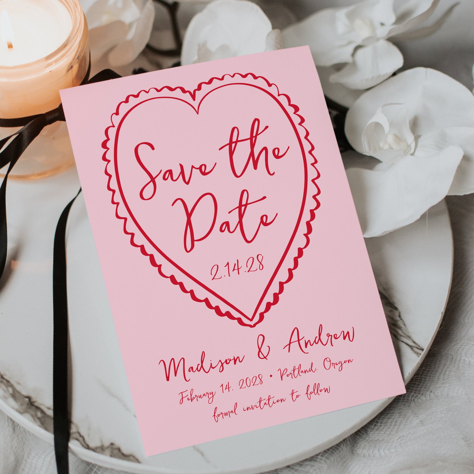 Pink 'Save the Date' card with red text on a decorative background